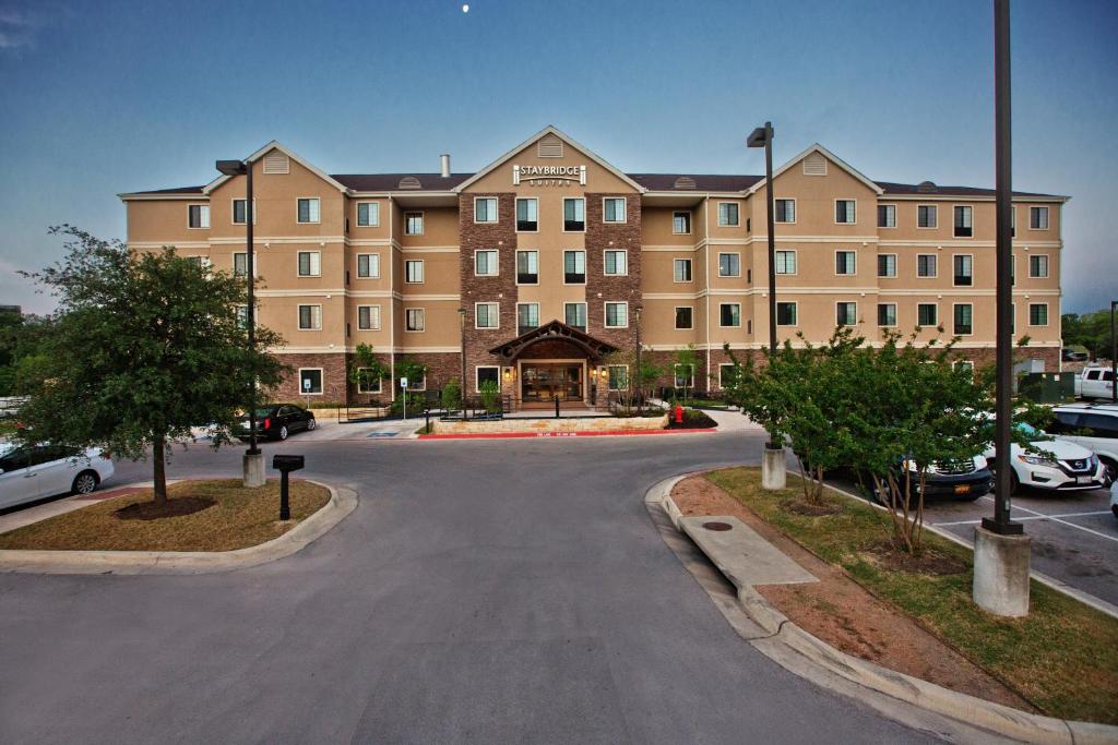 奥斯汀Staybridge Suites Austin South Interstate Hwy 35, an IHG Hotel的前面有一条街道的大建筑