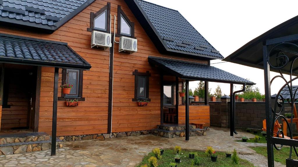 斯维季亚济Садиба For Rest的一间拥有黑色屋顶和庭院的木屋