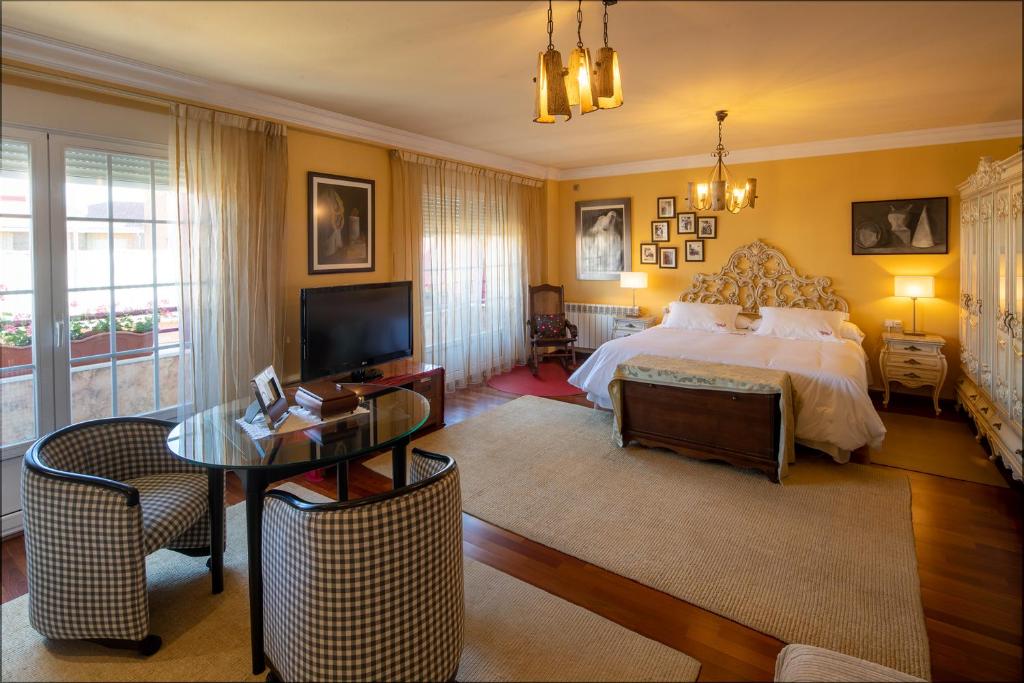 阿斯托加埃尔德斯坎索德温迪酒店的一间卧室配有一张床、一张桌子和一台电视