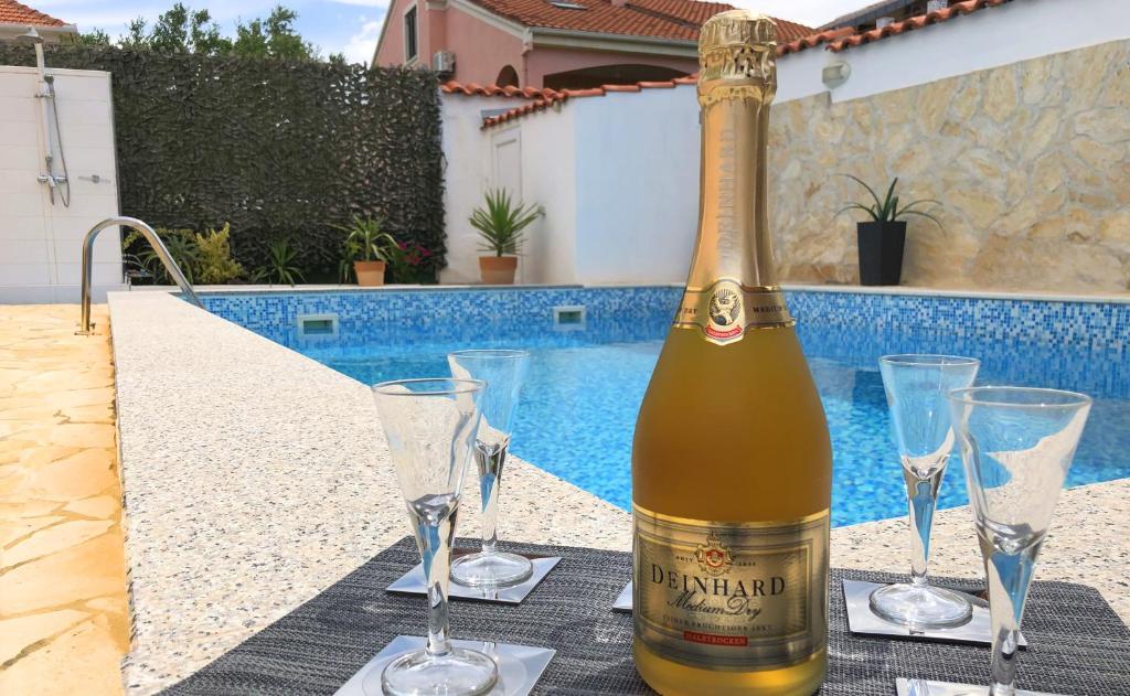 扎达尔Villa Sanda with Private Pool的一张桌子上摆放着一瓶葡萄酒和酒杯