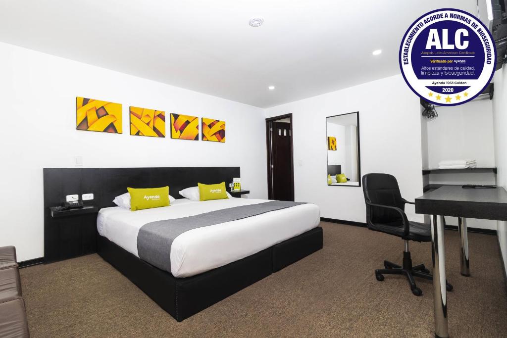 波哥大Ayenda 1063 Golden的酒店客房配有一张床、一张书桌和一张书桌。