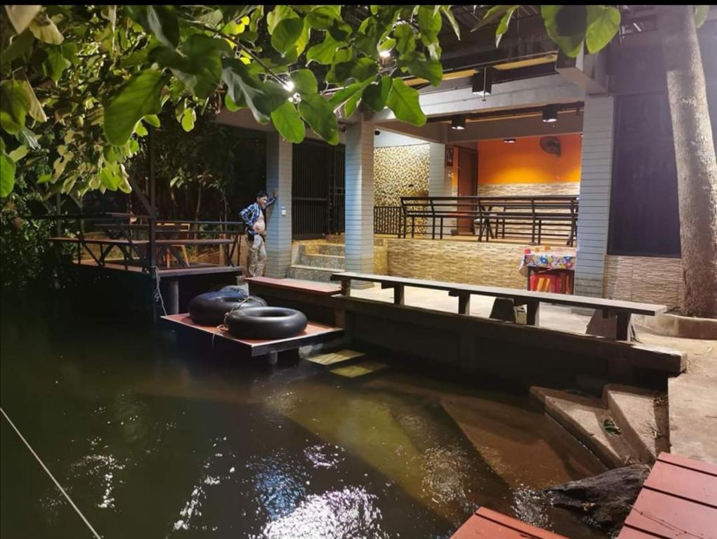班康卡臣碧差汶府河小屋旅馆的一个人站在水中的船上