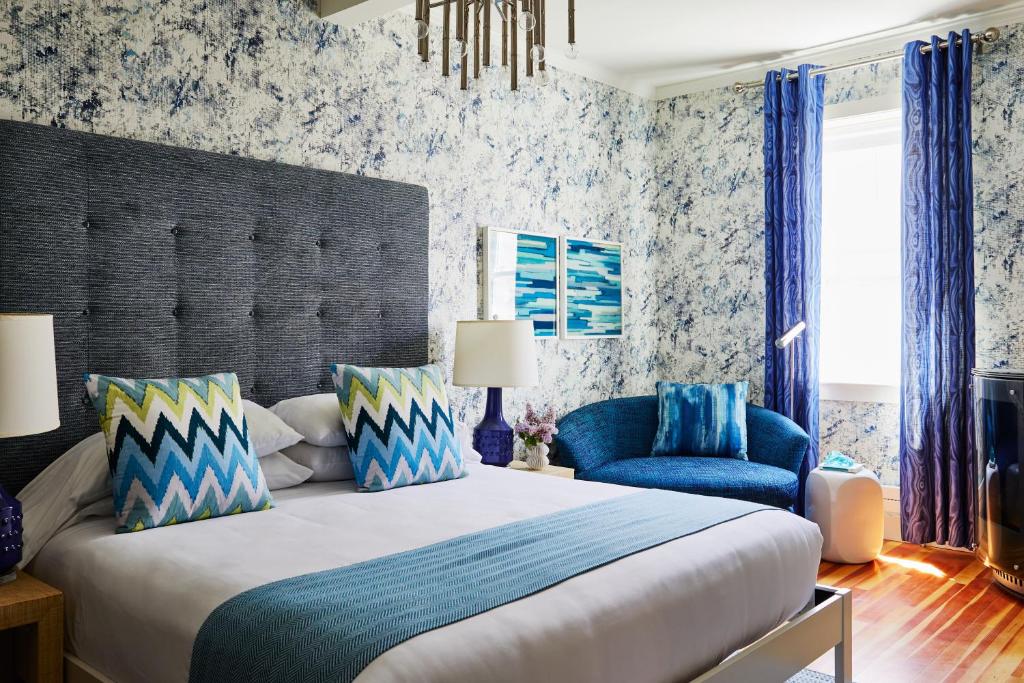 纽波特The Attwater的一间卧室配有一张大床和一张蓝色椅子