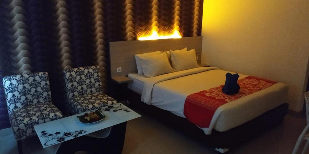 美娜多万鸦老梅尔斯宾馆的酒店客房带一张床、一张桌子和椅子