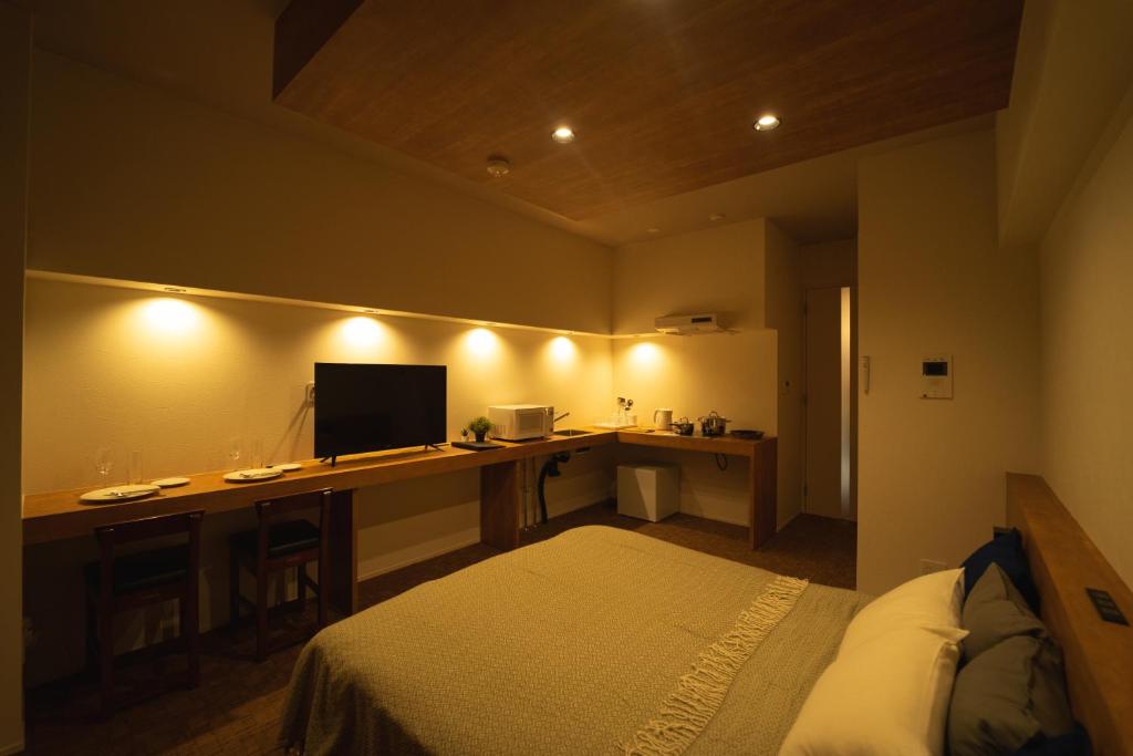 福冈HIT Tenjin的一间卧室配有一张床和一张带电脑的书桌