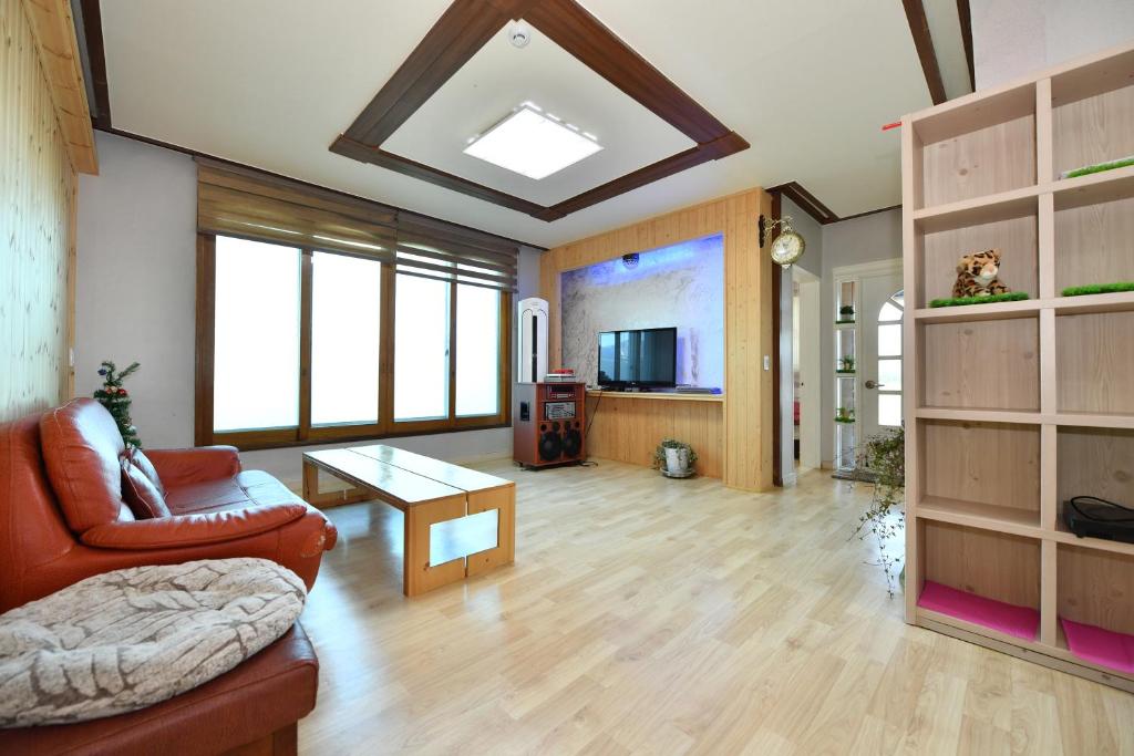 束草市Sokcho Daemyung Pension的客厅配有沙发和桌子