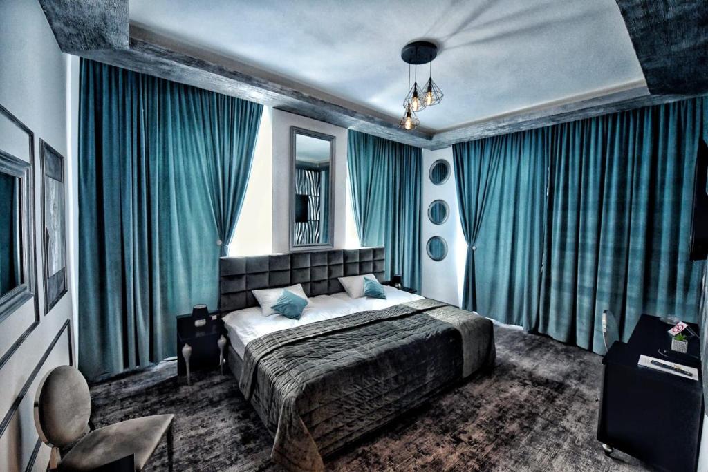 DetaHotel Bellavista Deta的一间卧室配有一张蓝色窗帘的床
