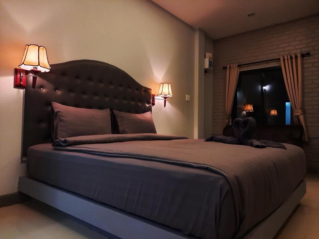 彭世洛Home resort的一间卧室配有一张大床和两盏灯