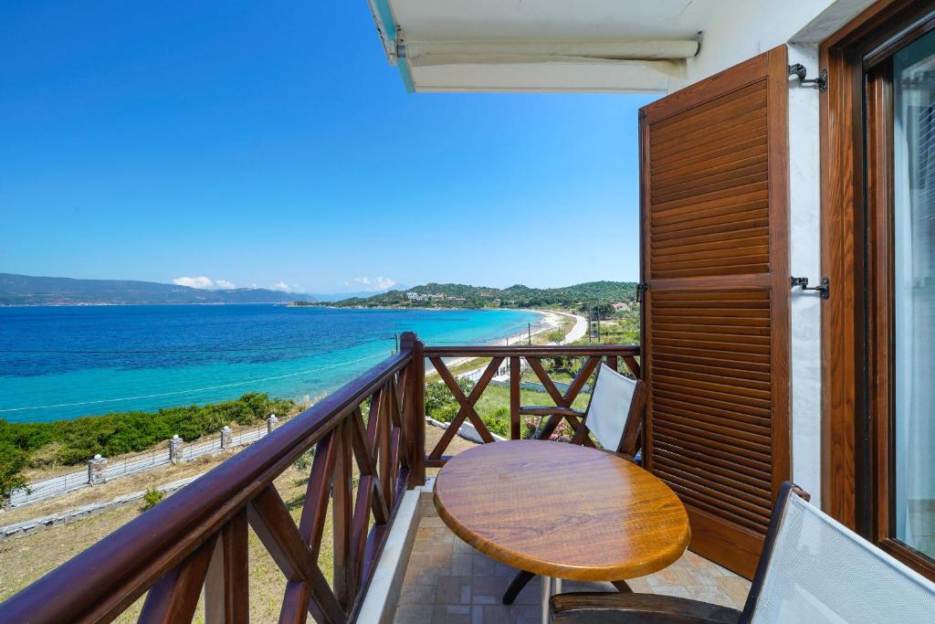 阿莫利亚尼岛Pansion Limanaki的阳台设有木桌,享有海景。