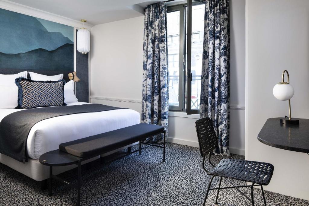 巴黎Hôtel Gramont的卧室配有床、椅子和窗户。