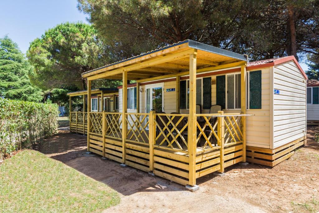 普拉Camping Adria Mobile Homes in Brioni Sunny Camping的院子内有大门廊的小房子