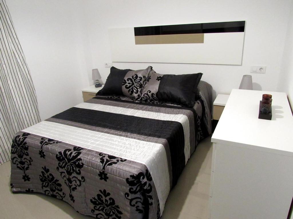 La ZarzaApartamentos La Bodega的一间卧室配有一张带黑白毯子的床