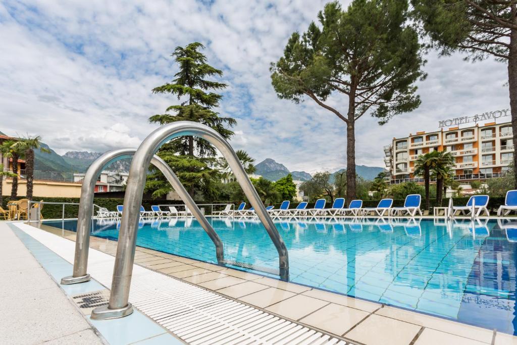 加尔达湖滨嘉德桑那酒店的一个带椅子的游泳池和一间酒店