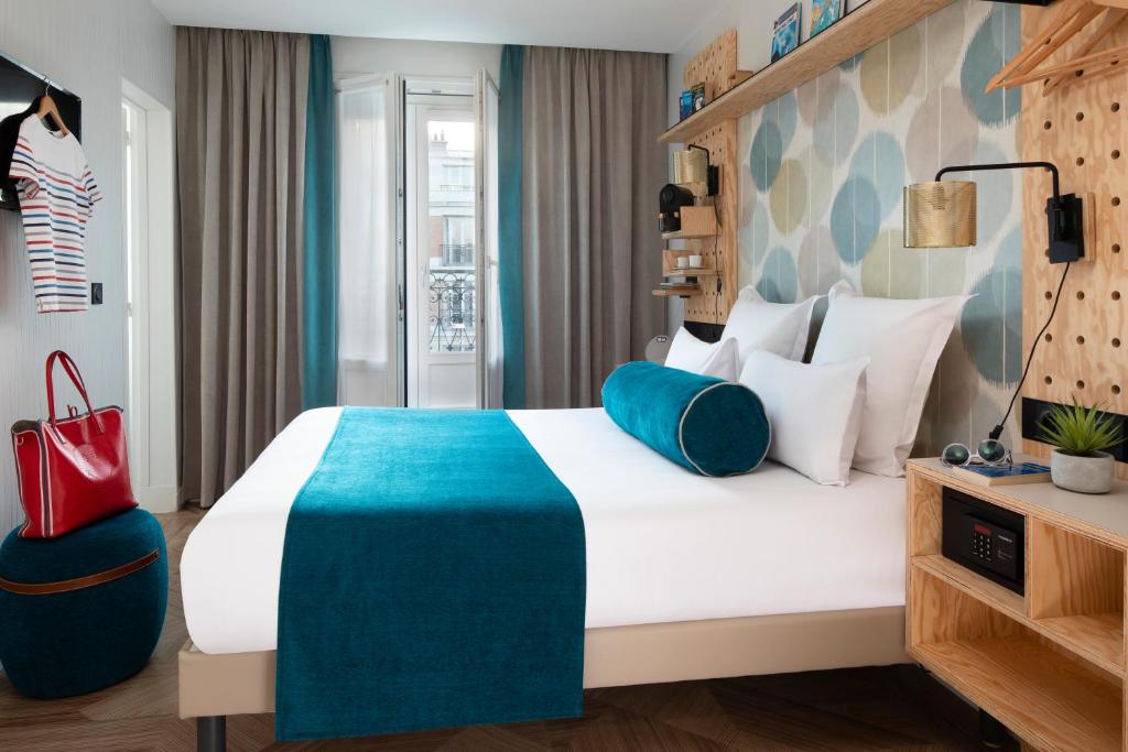 巴黎Hôtel LOCOMO的酒店客房配有一张带蓝色毯子的大床