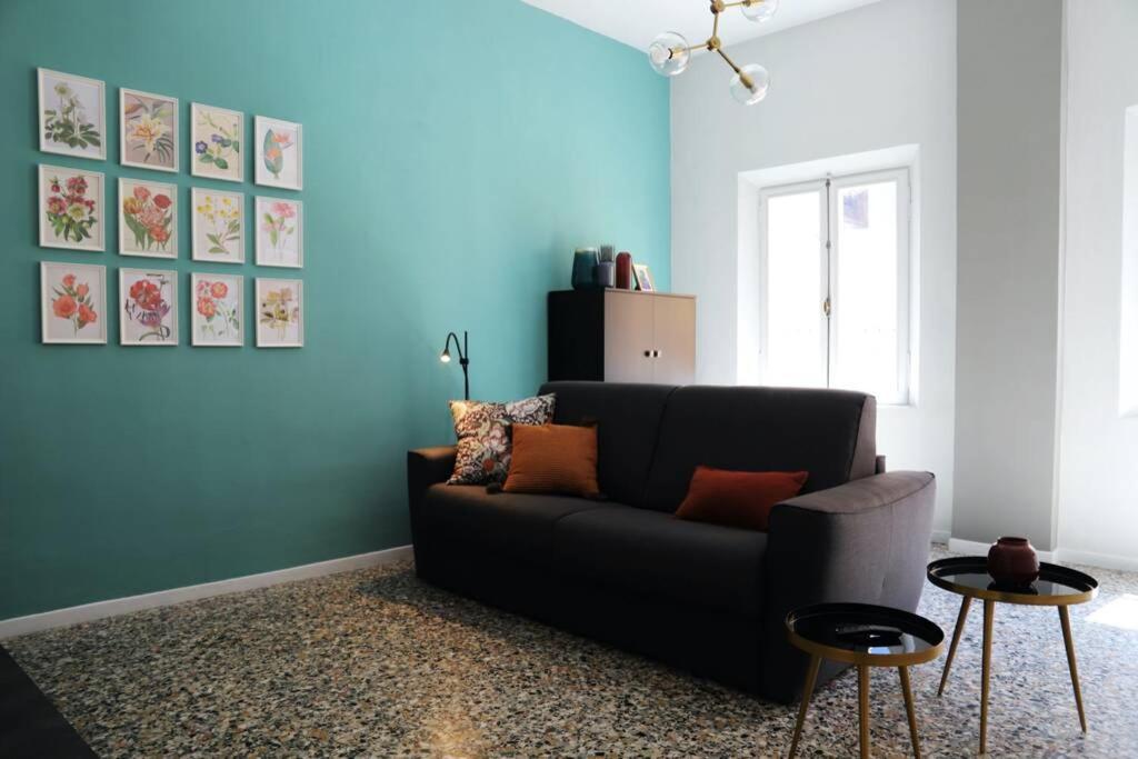 摩德纳La casa in via della Torre的客厅配有黑色沙发和蓝色的墙壁