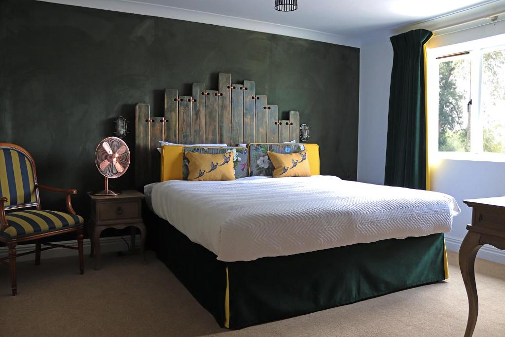 瓦灵福德西陵福特桥酒店的一间卧室配有一张带大床头板的床