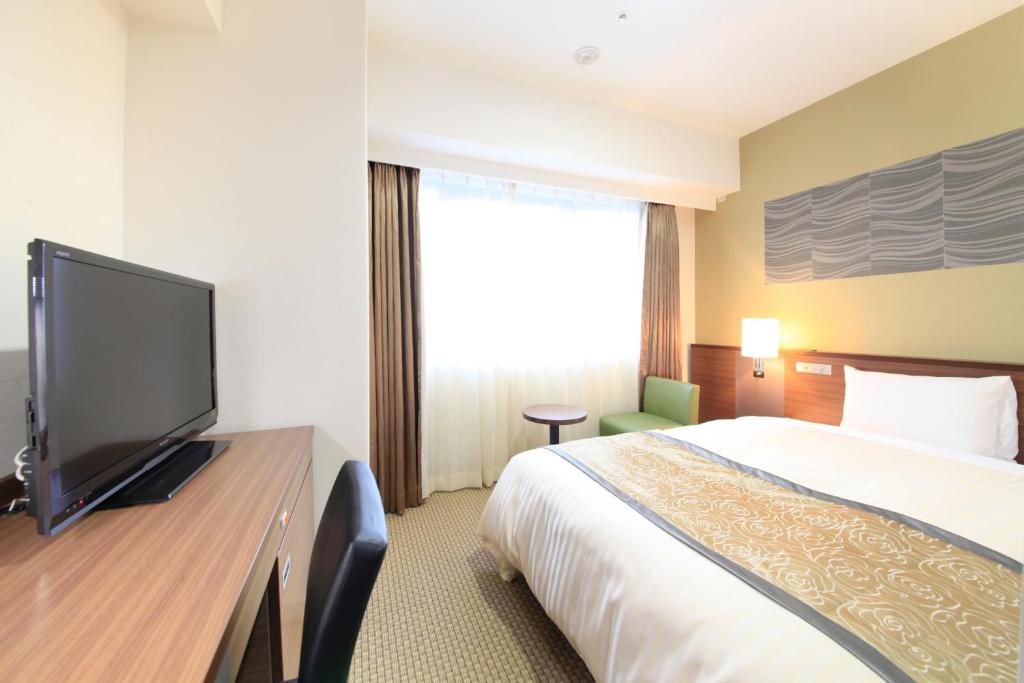 札幌Vessel Inn Sapporo Nakajima Park的配有一张床和一台平面电视的酒店客房