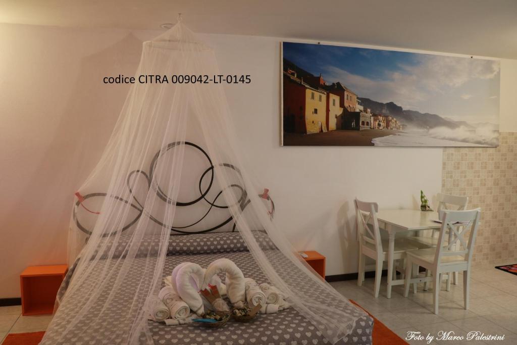 诺利Casetta delle Fate , sport e natura的一间卧室配有一张带天蓬和桌子的床