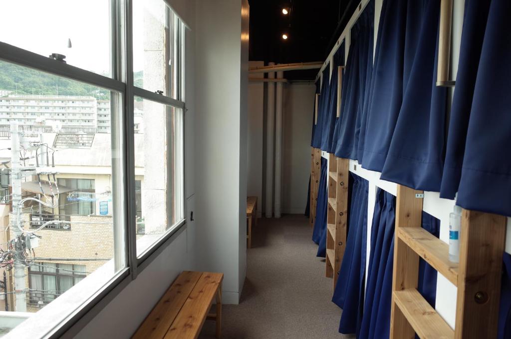 热海bnb+Atami Resort的走廊上设有蓝色窗帘和窗户