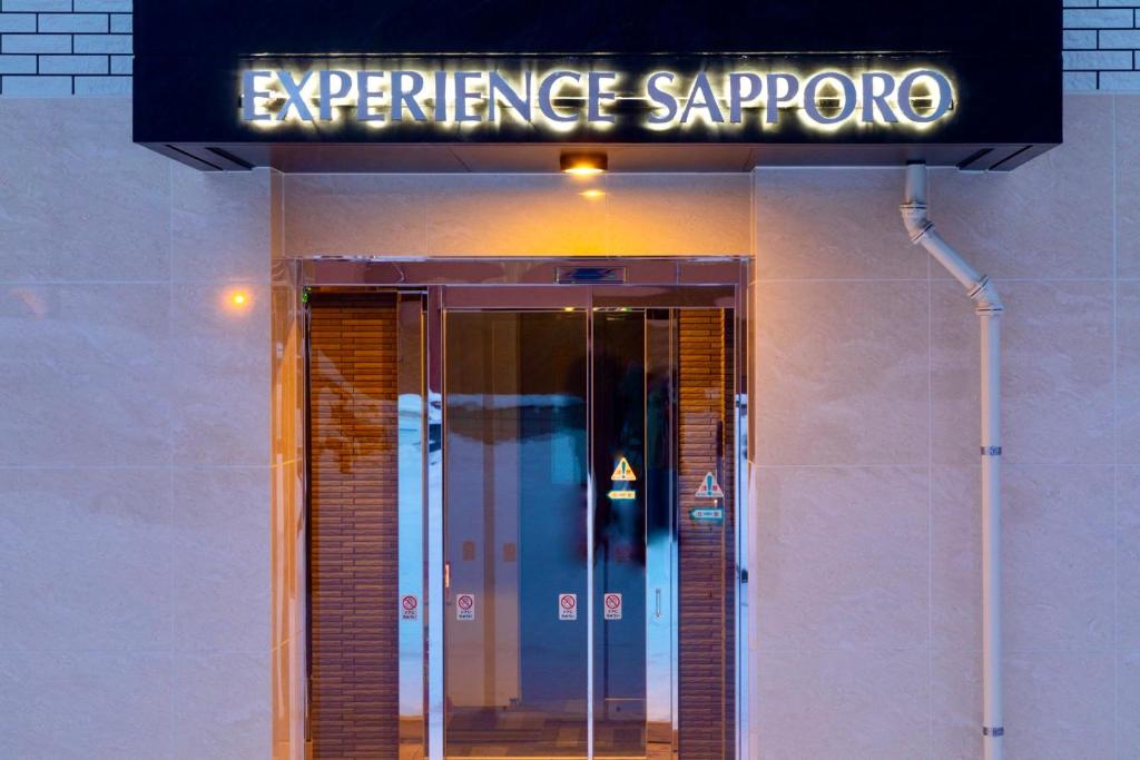 札幌Experience Sapporo的带有标志的建筑物入口处的入口