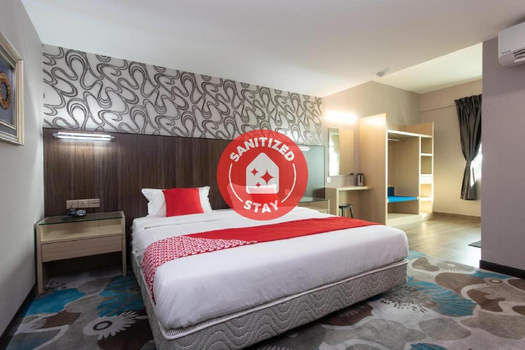 KeningauSuper OYO 89375 Regent Hotel的酒店客房的床铺上标有红色的标志
