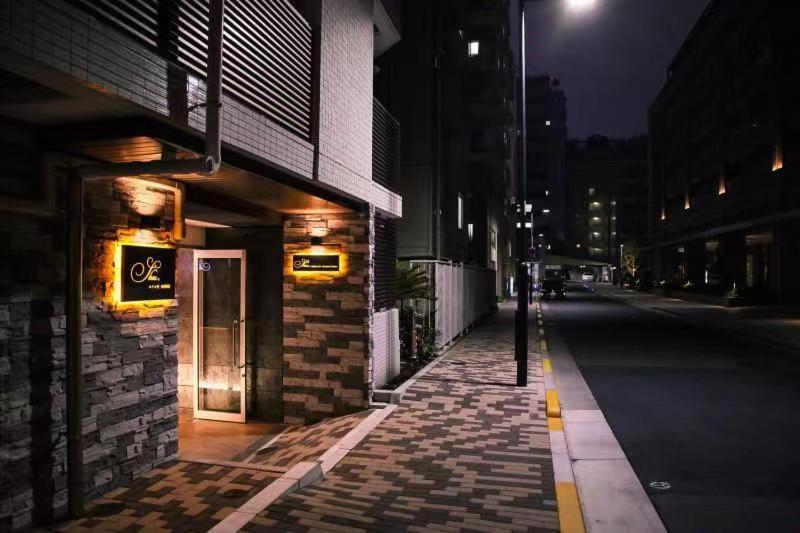 东京Hotel Shu的一条空荡荡的城市街道,晚上有一座建筑