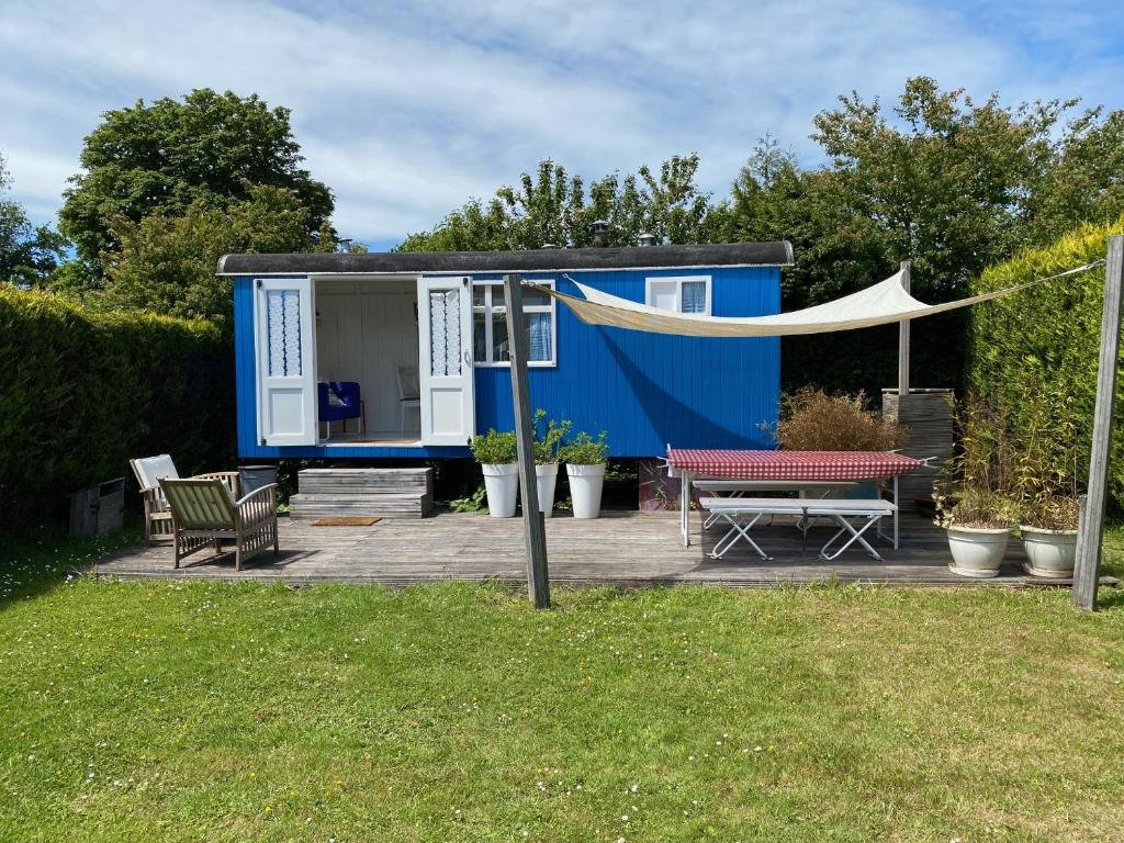 东福尔讷Little blue house (on the campsite)的蓝色的小房子,配有野餐桌和帐篷