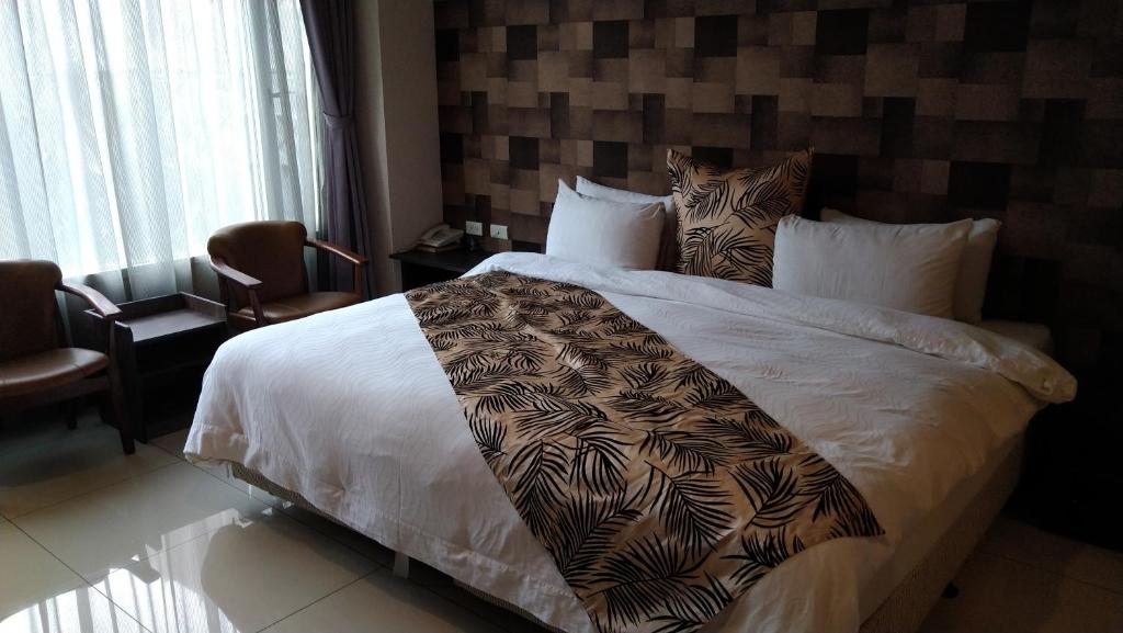 嘉义市波顿精品旅馆的卧室配有一张白色大床,床上有毯子