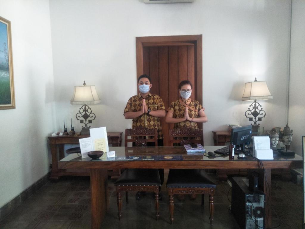 日惹格拉哈吉纳斯赫科塔巴鲁酒店的两个人站在桌子上戴面具