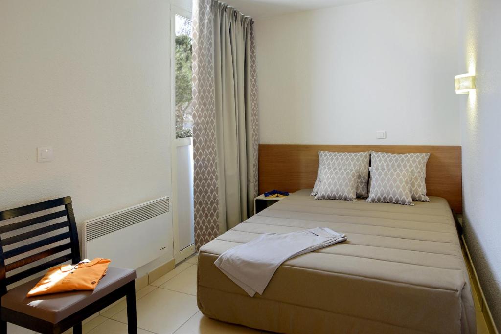 拉格朗德默特瑞斯迪尔大丛林公寓酒店的卧室配有床、椅子和窗户。