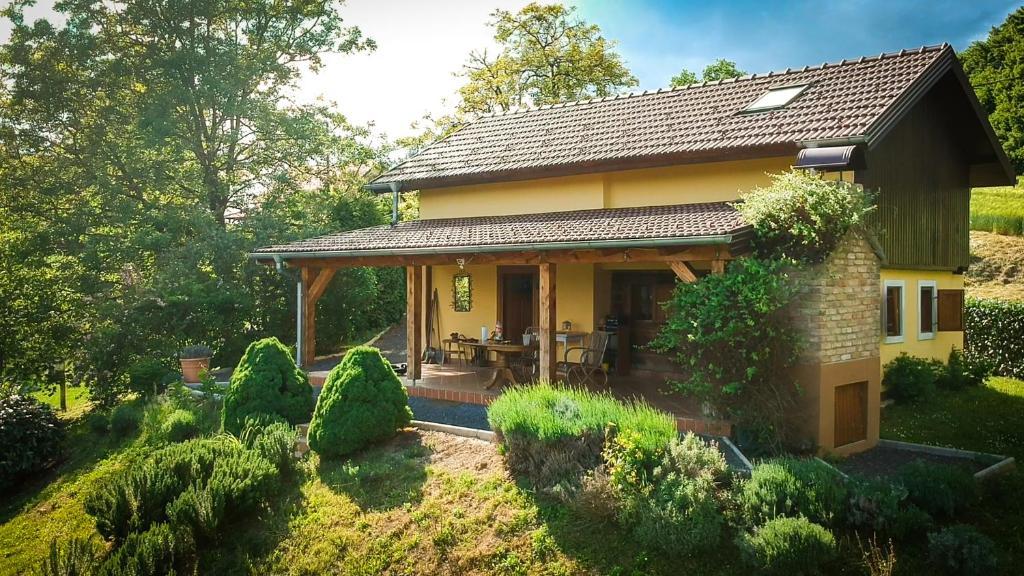 Ravnice-DesinićkeGreen Hills Cottage in Zagorje with magnificent view的庭院中一座小黄色房子,设有庭院