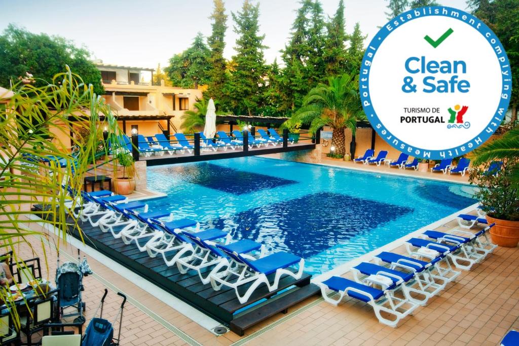 阿尔布费拉巴拉亚马酒店的游泳池配有椅子和写有干净安全标志的标志