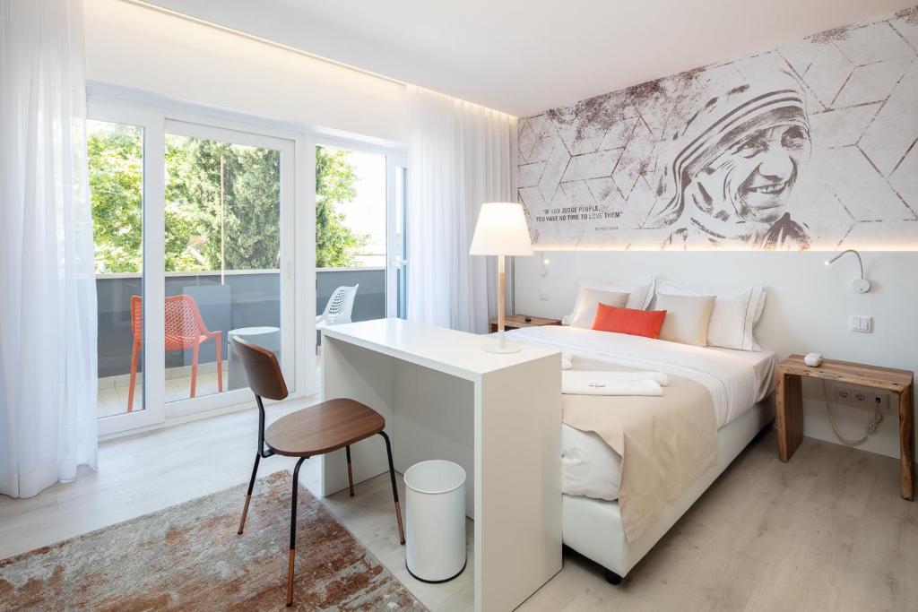 里斯本The ICONS Lisbon Central Hotel的一间卧室配有一张特大号床和一张书桌