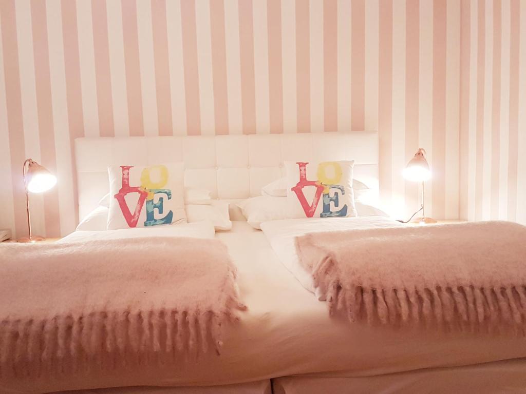 维也纳施瓦尔贝酒店的一间卧室配有两张带枕头和两盏灯的床。