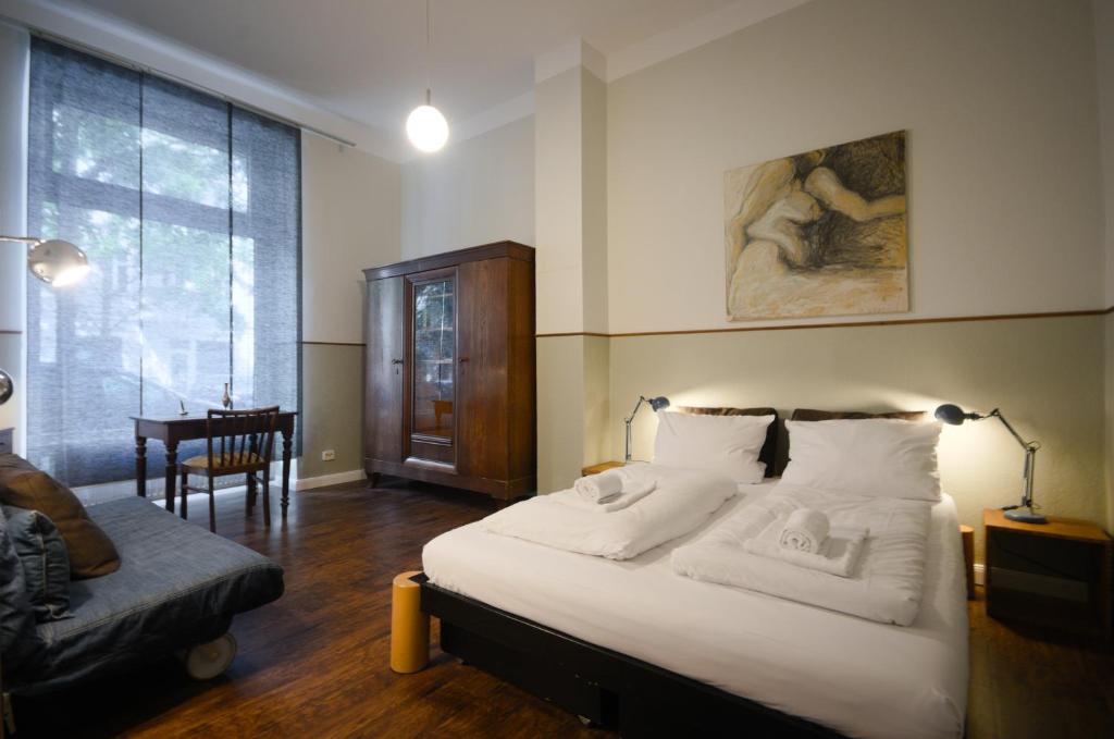 柏林Altbauwohnung mit 3 Bädern (PB6)的卧室配有床、椅子和窗户。