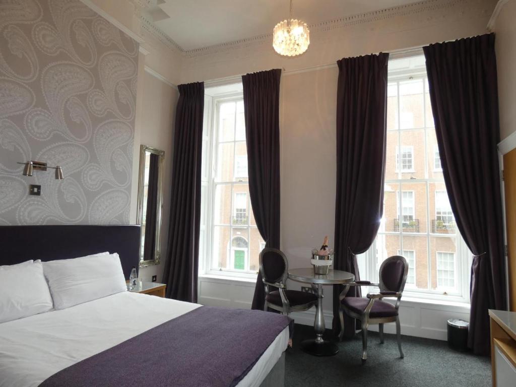 都柏林杰克逊科特酒店的酒店客房带一张床、一张桌子和窗户
