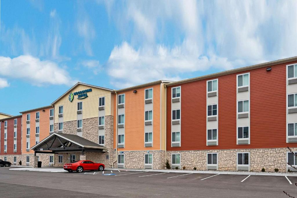 斯帕克斯WoodSpring Suites Reno Sparks的停车场里有一个红色的汽车的酒店