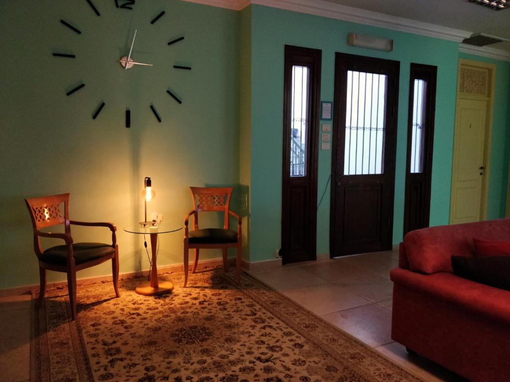 海法Hostel Roks的客厅配有墙上的时钟和椅子