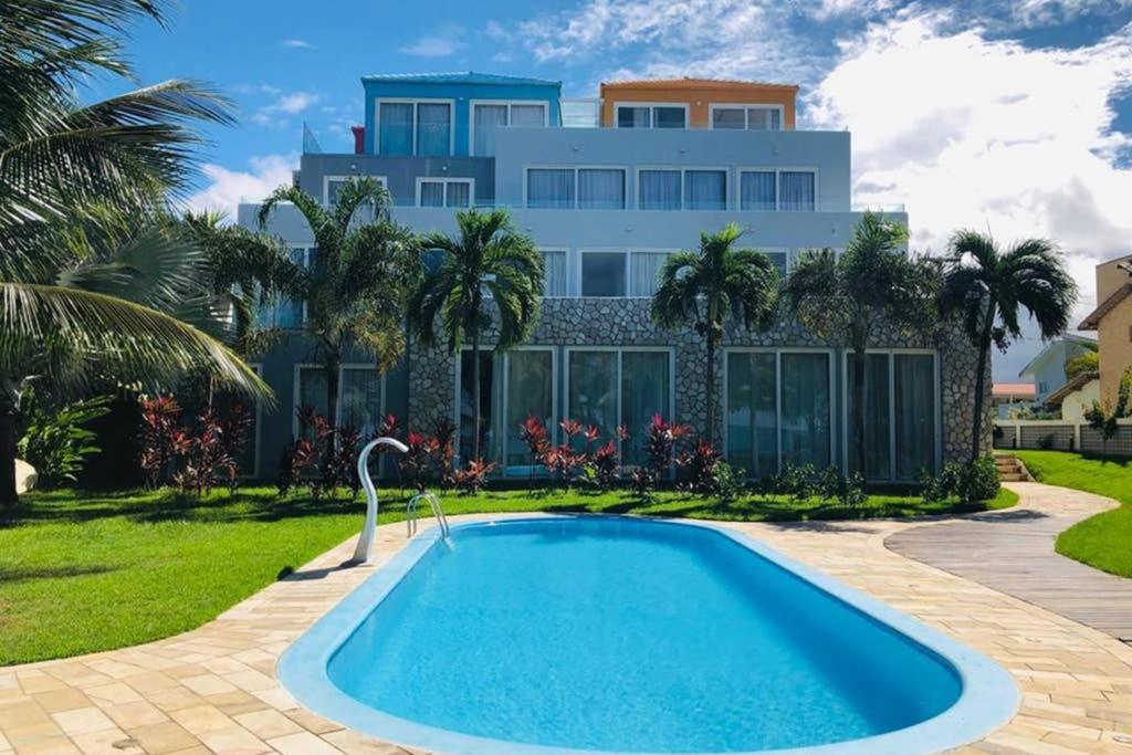 普拉亚多斯卡内罗斯Apart Hotel Praia dos Carneiros Apto 101的房屋前有游泳池的房子