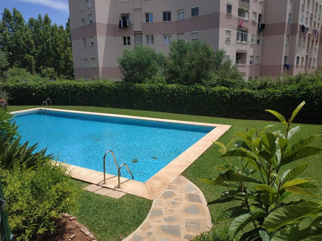 马贝拉Amplio apartamento Marbella的一座游泳池,位于一座建筑旁的院子内
