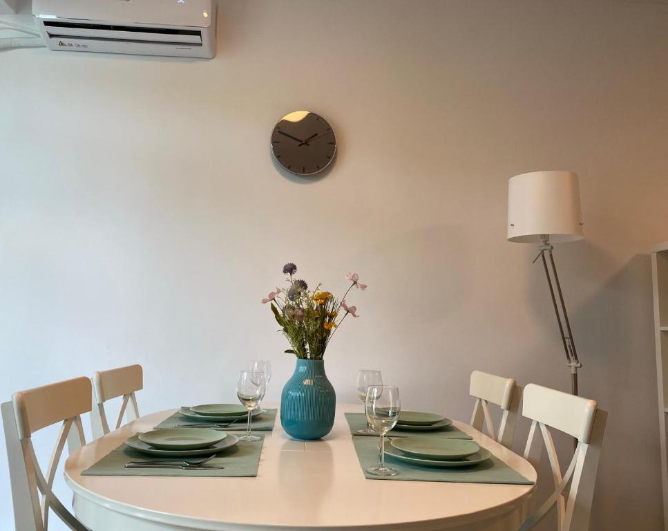 北马马亚-讷沃达里Deko Apartments Alezzi Beach Mamaia的一张带鲜花的蓝色花瓶的餐桌