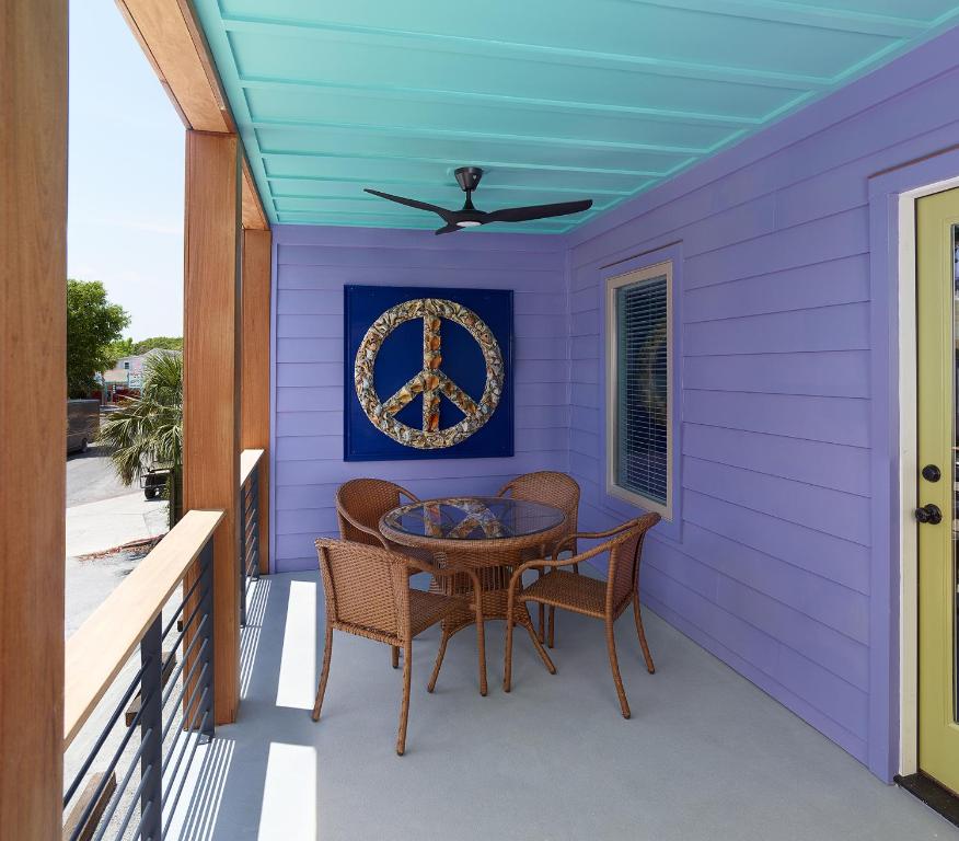 富丽海滩Folly Vacation Great Location, Super Cute & Spacious Apt B的紫色的房子,门廊上配有桌椅