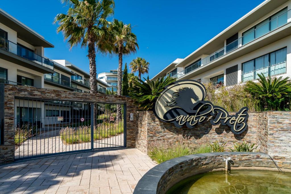 楼尔BmyGuest - Cavalo Preto Beach Apartment的带有标志的酒店入口处的大门