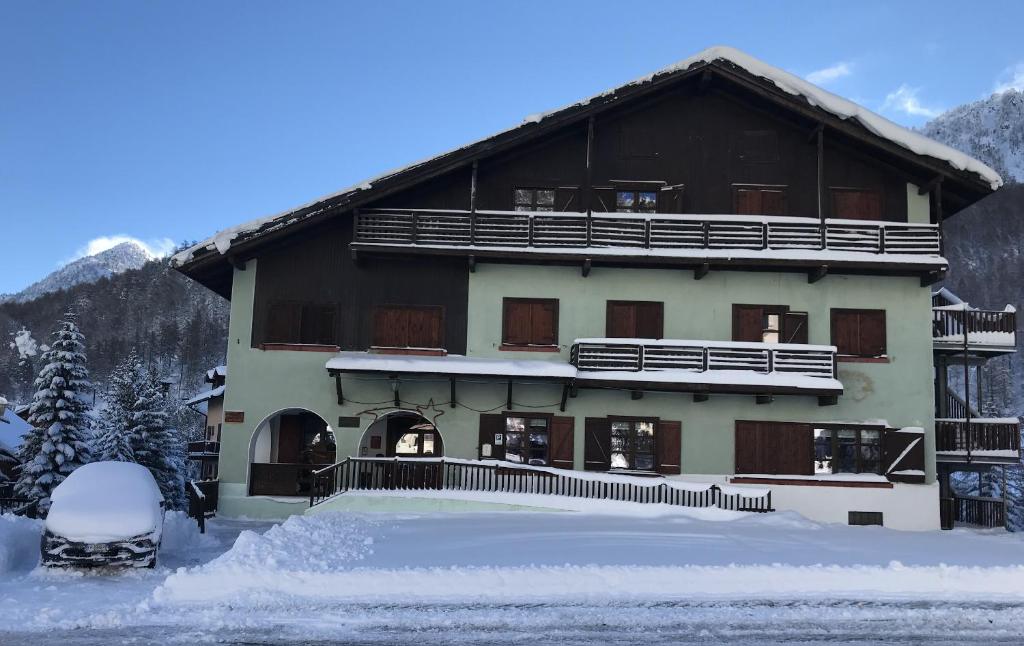 克拉维埃Chalet della Luna ATTENZIONE lavori di ristrutturazione in corso IMPALCATURA的前面有雪的大建筑