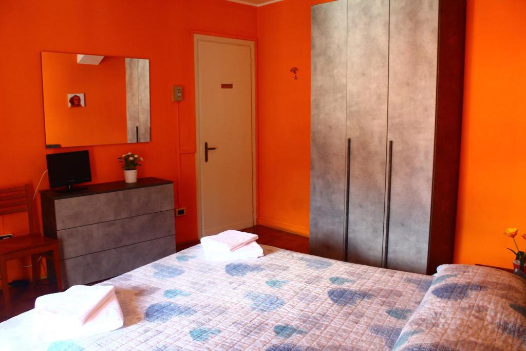 贝拉诺德拉戈旅馆的一间卧室设有橙色的墙壁、一张床和橱柜