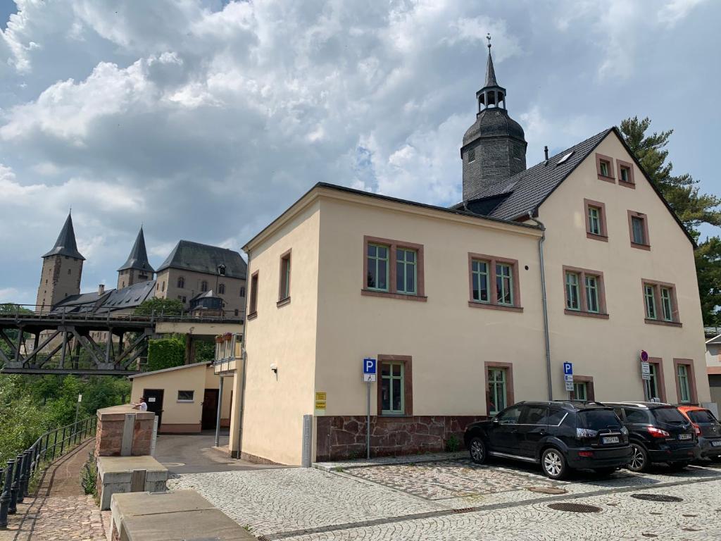 RochlitzFerienwohnung am Schloss Rochlitz的停车场内有车辆的建筑物
