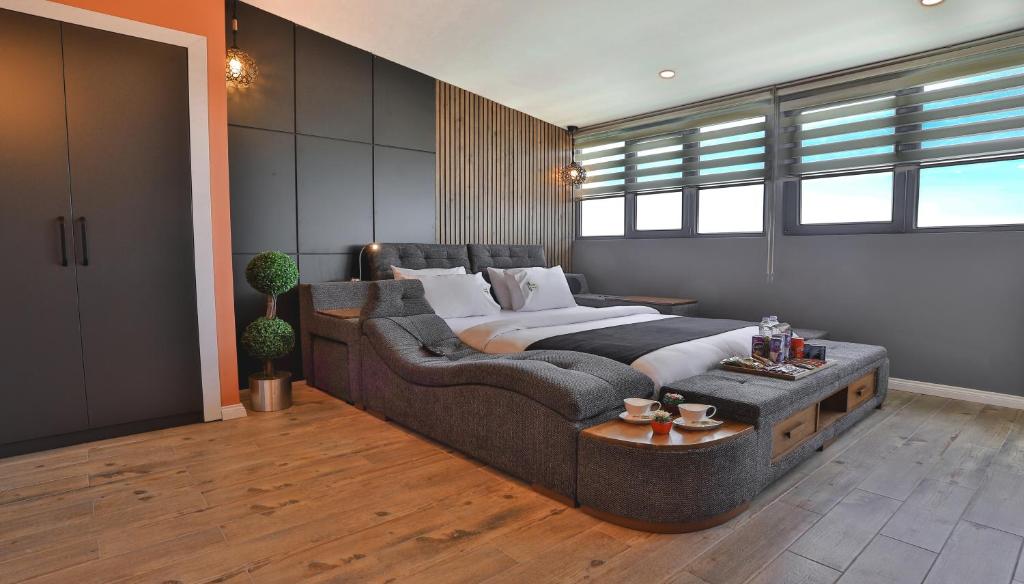 特拉布宗SWEET HOME SUiTE HOTEL的一间卧室配有一张大床和一张沙发