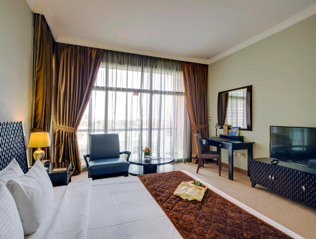 阿布扎比欧力克斯酒店的酒店客房设有一张大床和一张书桌。