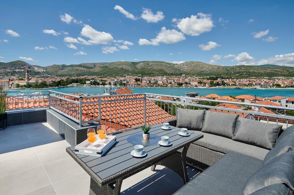 特罗吉尔Apartments & Rooms Žaja的阳台的天井配有桌椅