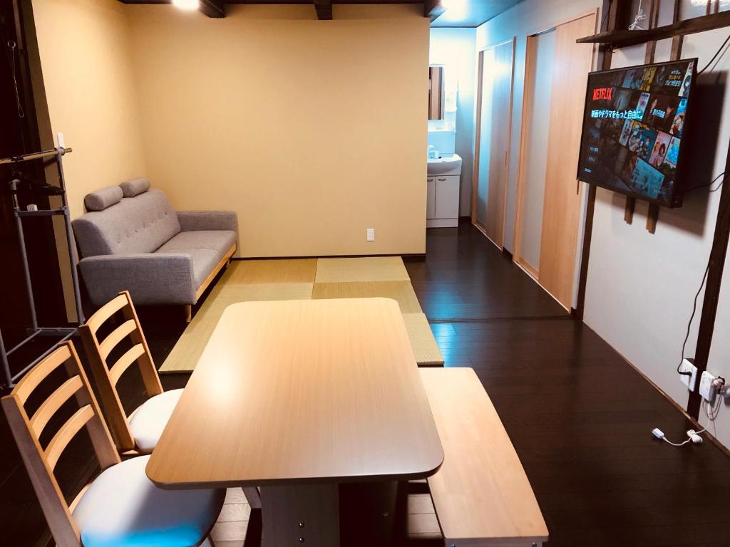高山Utatei Sou的客厅配有桌子和沙发